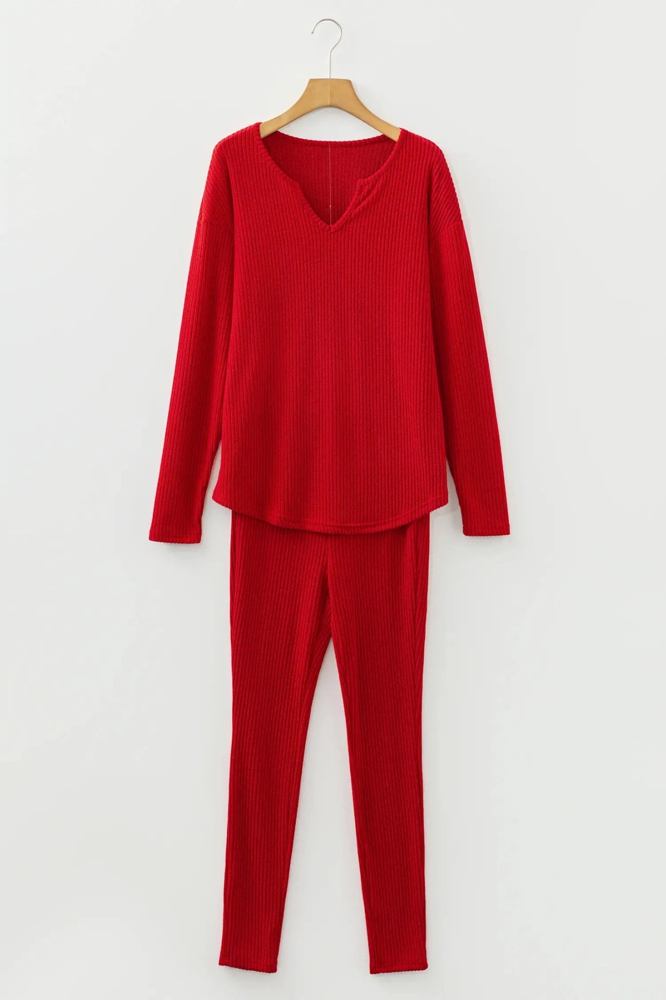 Red ribbed long-sleeve top and pants set on a hanger against a white background