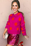 Woman modeling bright pink polka-dot sweater & sequin skirt.