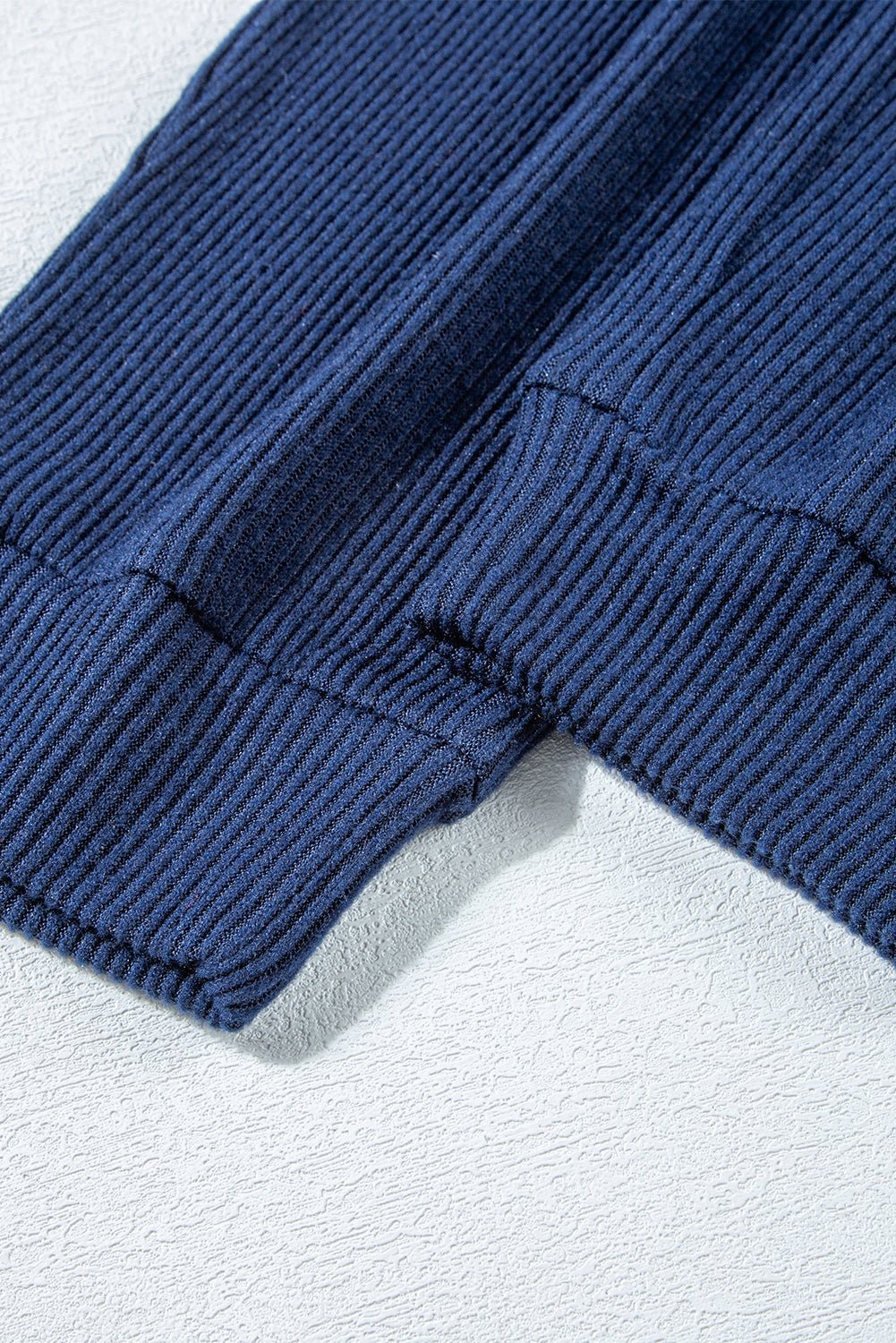 Close-up of blue corduroy pants on a light gray background