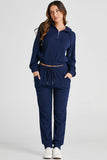 Woman wearing a navy blue tracksuit on a light gray background