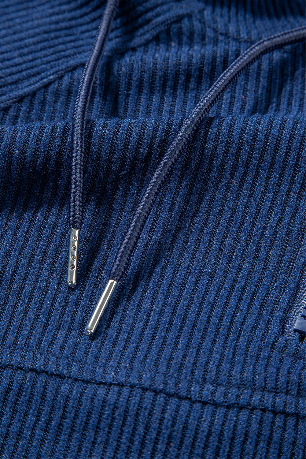 Close-up of blue corduroy fabric with a focus on texture and stitching.