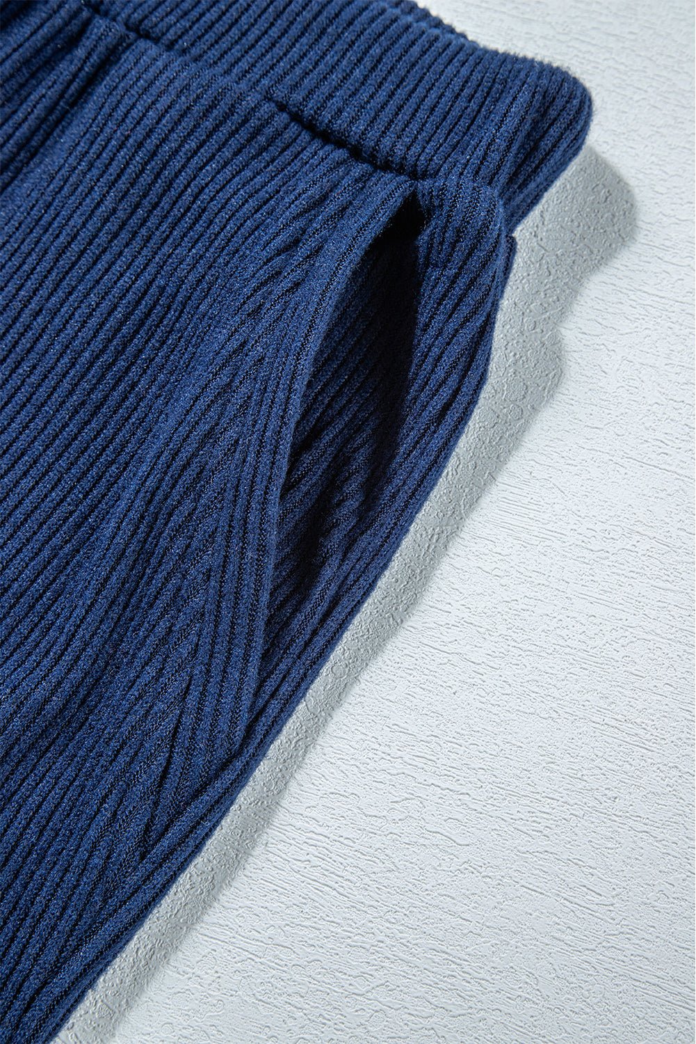 Close-up of blue ribbed fabric on a light gray background