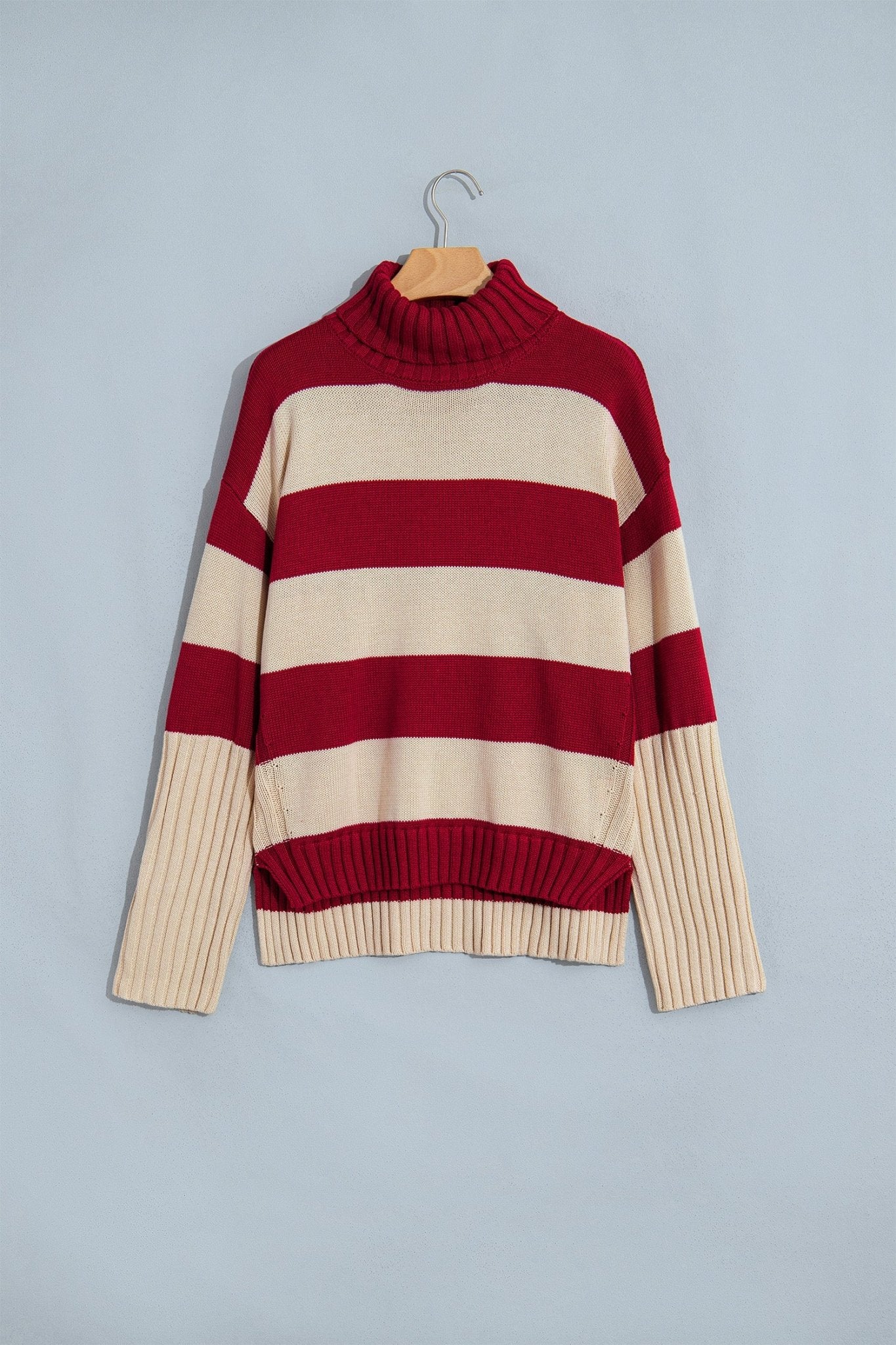 Burgundy-cream striped ribbed turtleneck sweater with cream cuffs and hem on hanger.