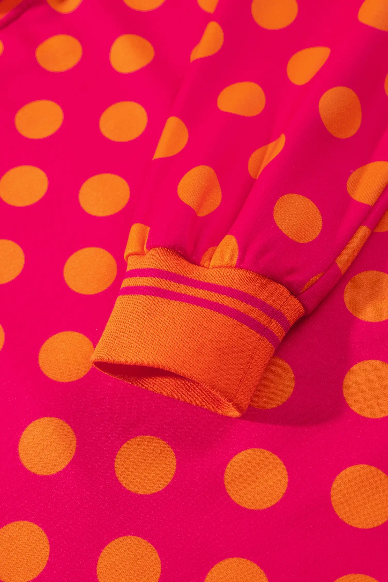 Close-up of striped ribbed cuff on rose polka dot sweatshirt