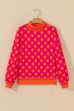 Rose sweatshirt with orange polka dots and striped mock neck on a hanger