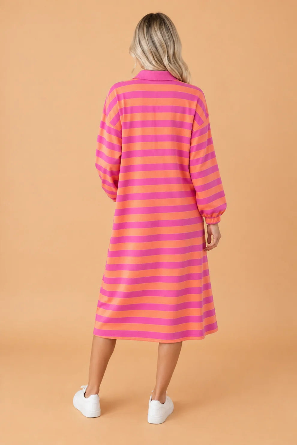 Back view of rose and orange stripe long sleeve polo midi dress with white sneakers