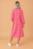 Back view of rose and orange stripe long sleeve polo midi dress with white sneakers