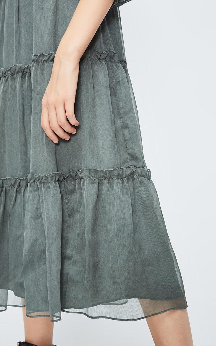 Green dress with ruffled layers on a white background