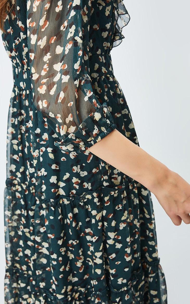 Floral patterned dress with sheer sleeves on a white background