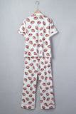 A two-piece short-sleeve pajama set hanging on a wooden hanger against a plain gray background. The pajama top and matching pants are white with an all-over repeating pattern of brown and white footballs.