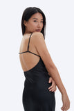Woman wearing a black slip dress on a white background