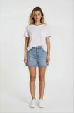 Woman wearing a white t-shirt and denim shorts on a plain background