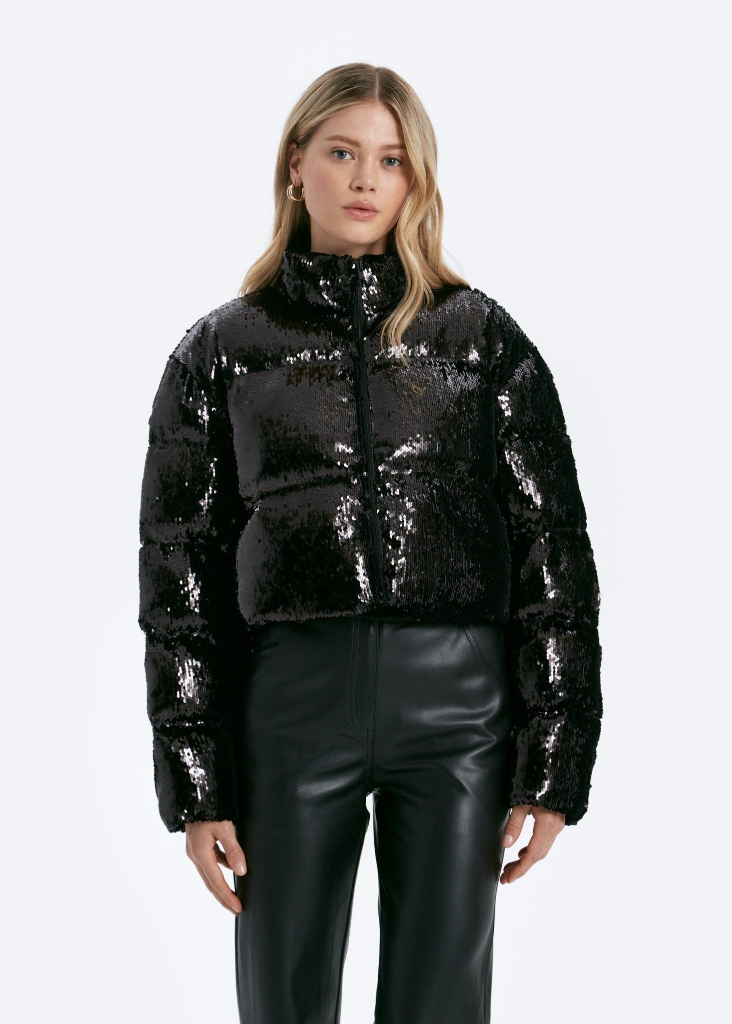 Woman wearing a black sequin jacket on a white background