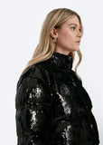 Person wearing a black sequin jacket on a white background