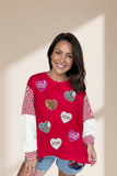 Woman wearing a red sweater with heart-shaped decorations on a beige background