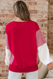 Person wearing a red and white sweater with a brick wall background