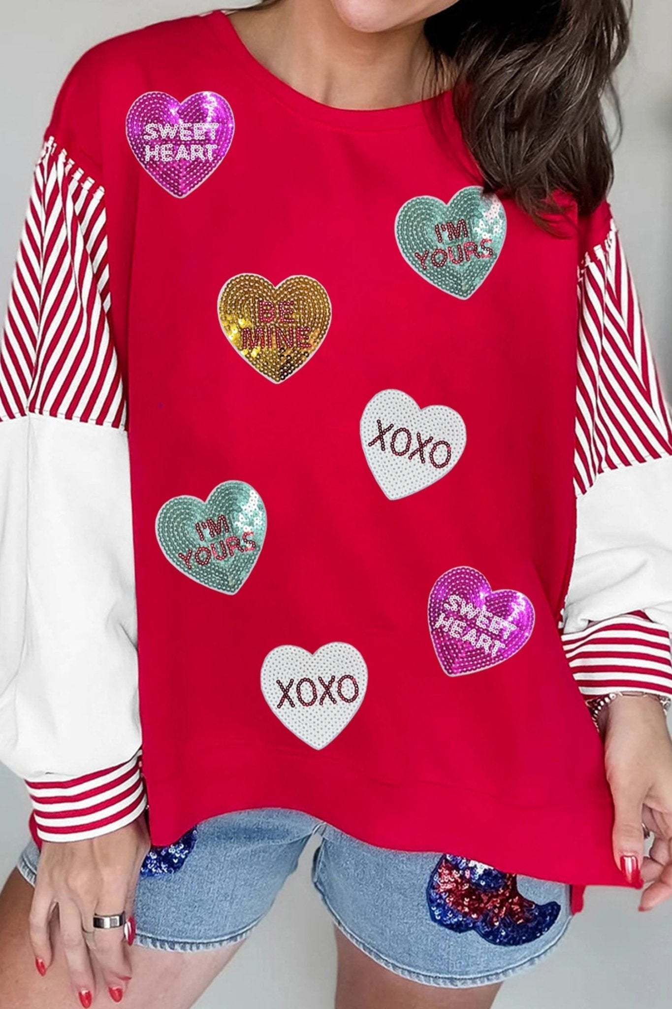 Red shirt with heart-shaped designs and text worn by a person