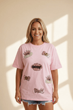 Woman wearing a pink t-shirt with various designs on a beige background