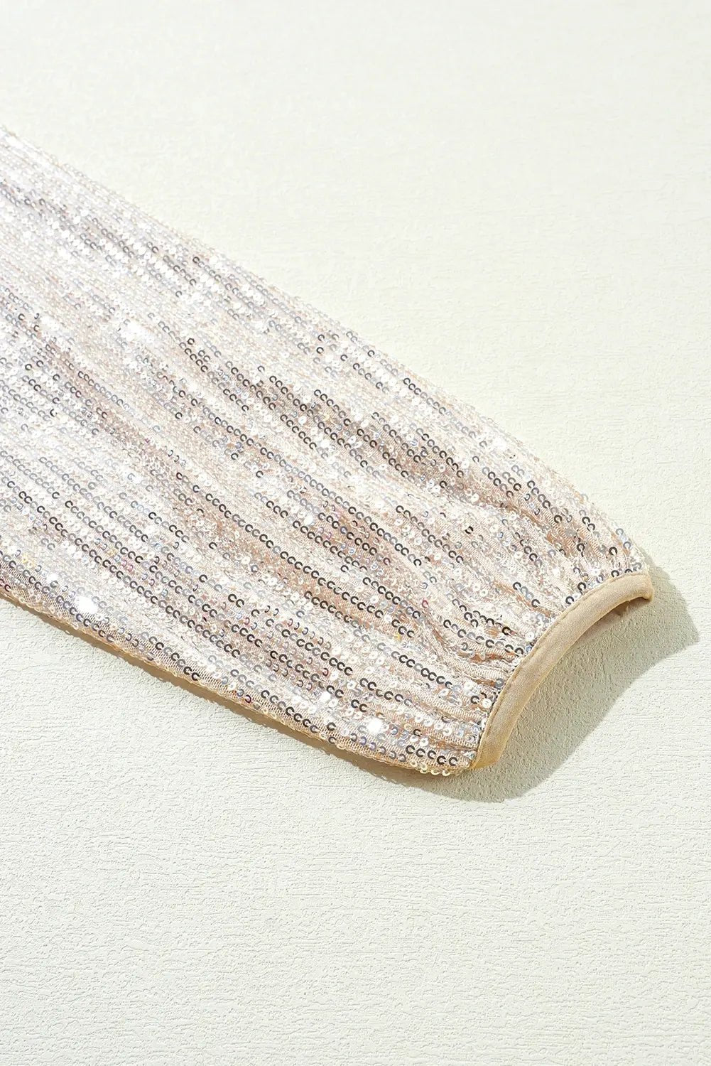 Close-up of a glittery fabric roll on a light background