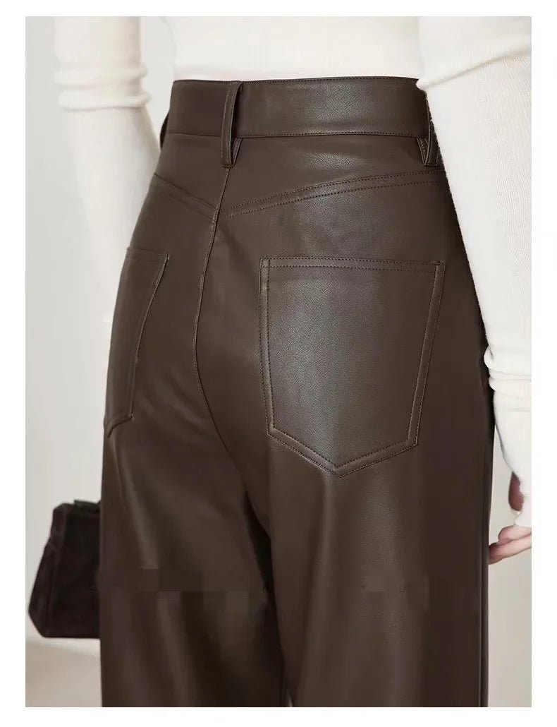 Brown leather pants worn by a person on a plain background