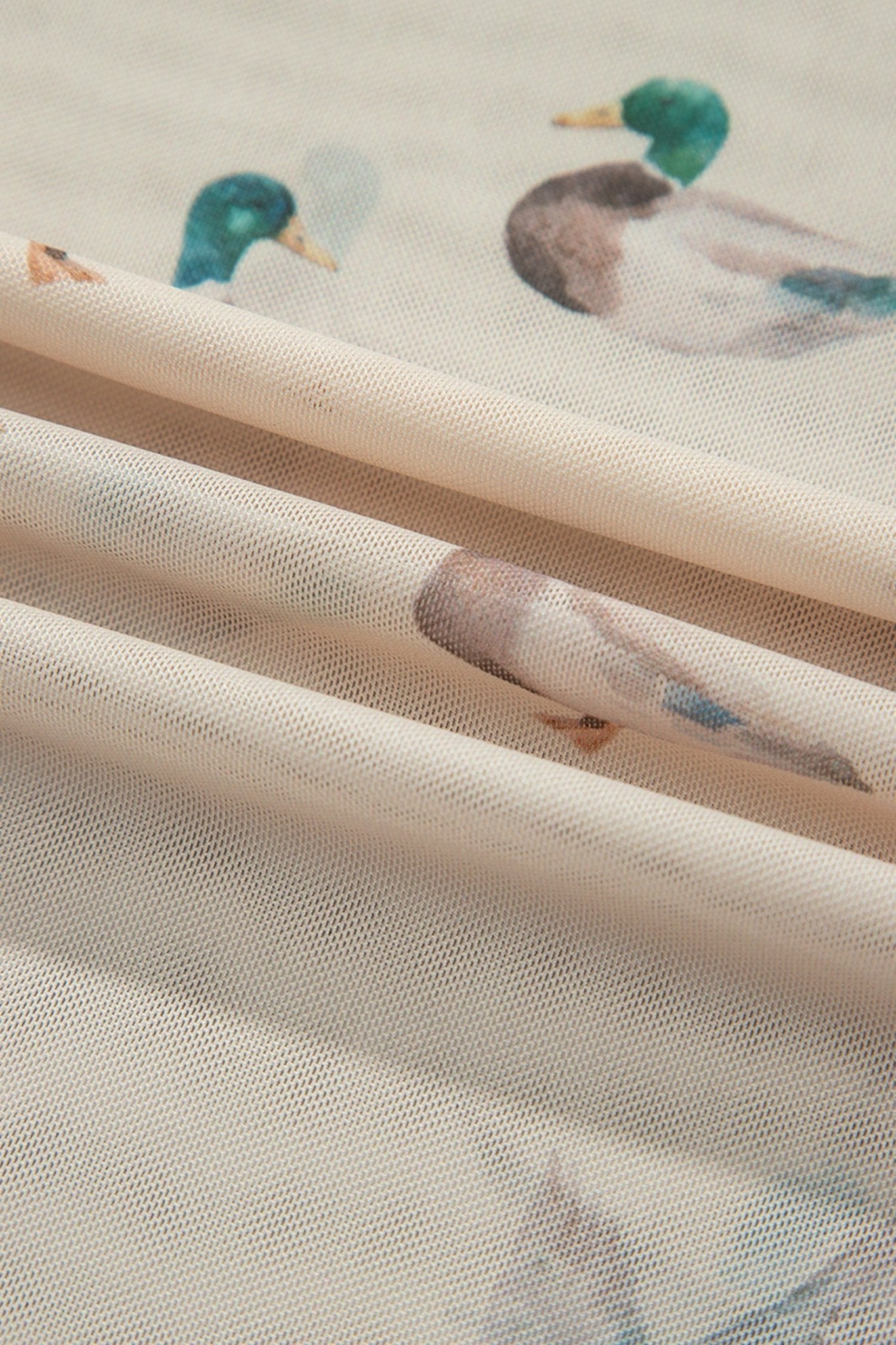 Sheer cream fabric with mallard print, layered in three diagonal rolls.