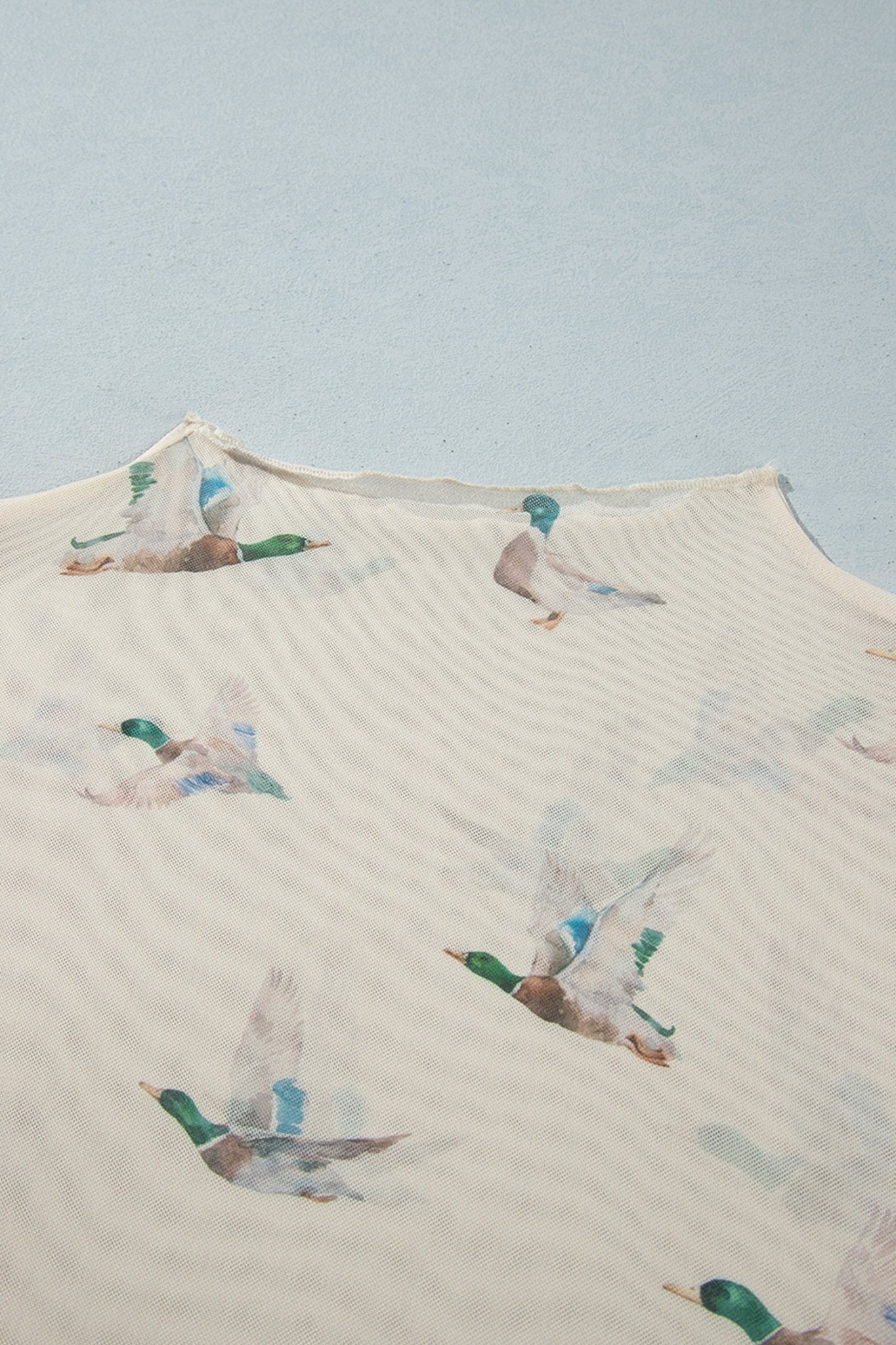 Cream fabric with muted green, blue, and brown flying mallard print.