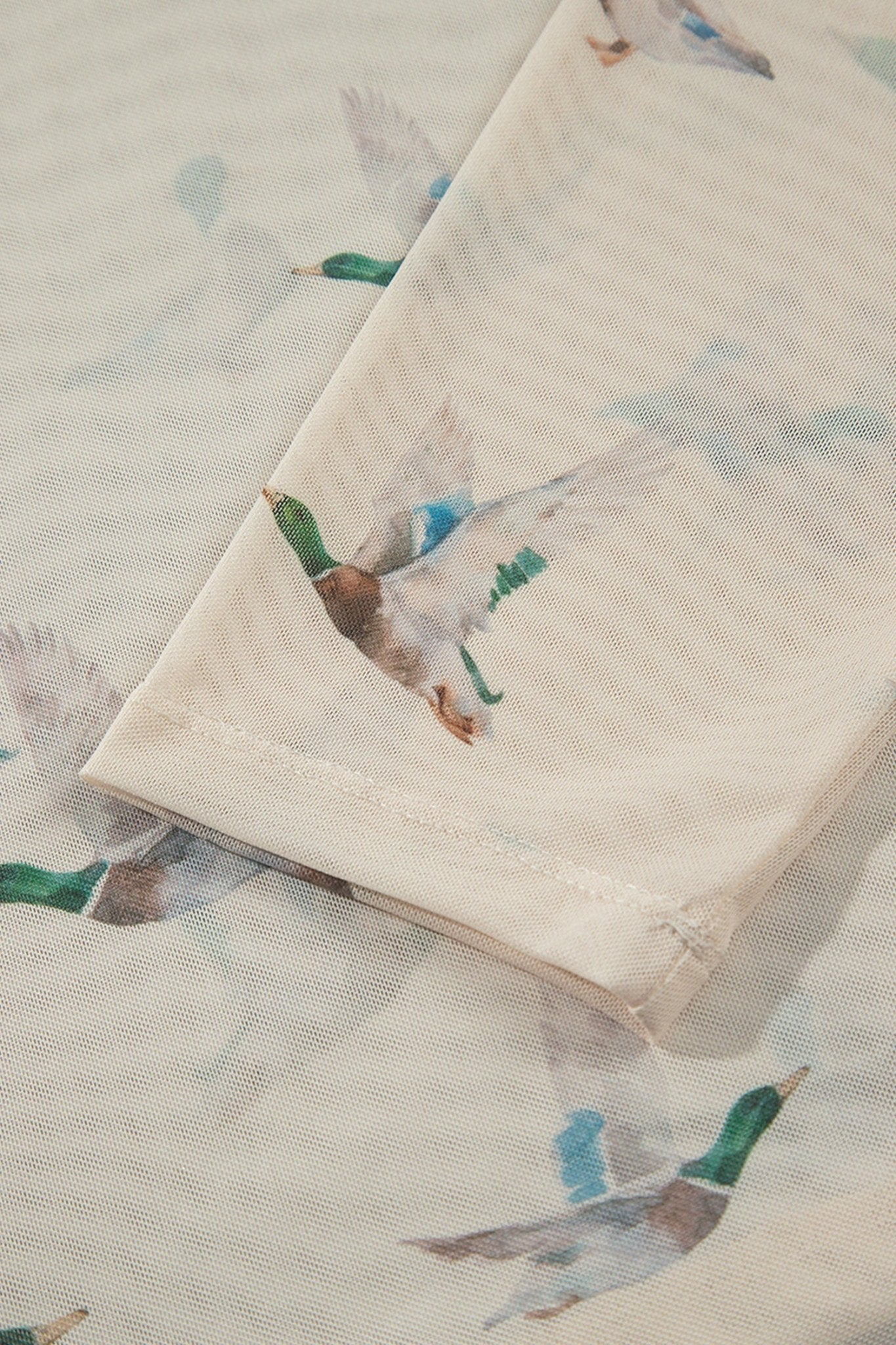 Folded cream cotton muslin napkin with mallard print on matching fabric.