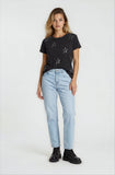 Woman wearing a black t-shirt with star patterns and light blue jeans on a white background