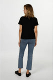 Woman wearing a black t-shirt and blue jeans on a white background