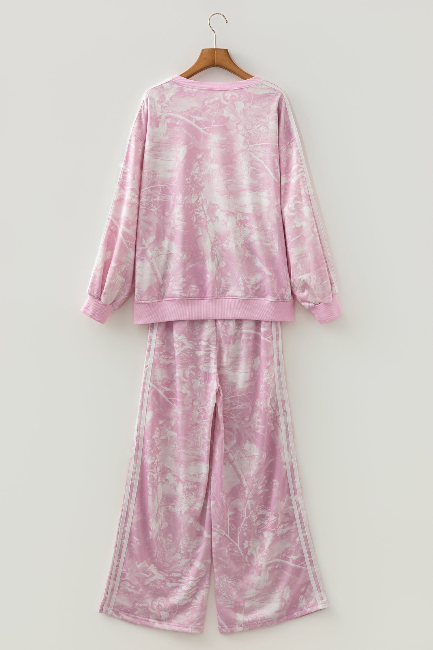Pink abstract print sweatshirt and wide leg pants set on a hanger, back view