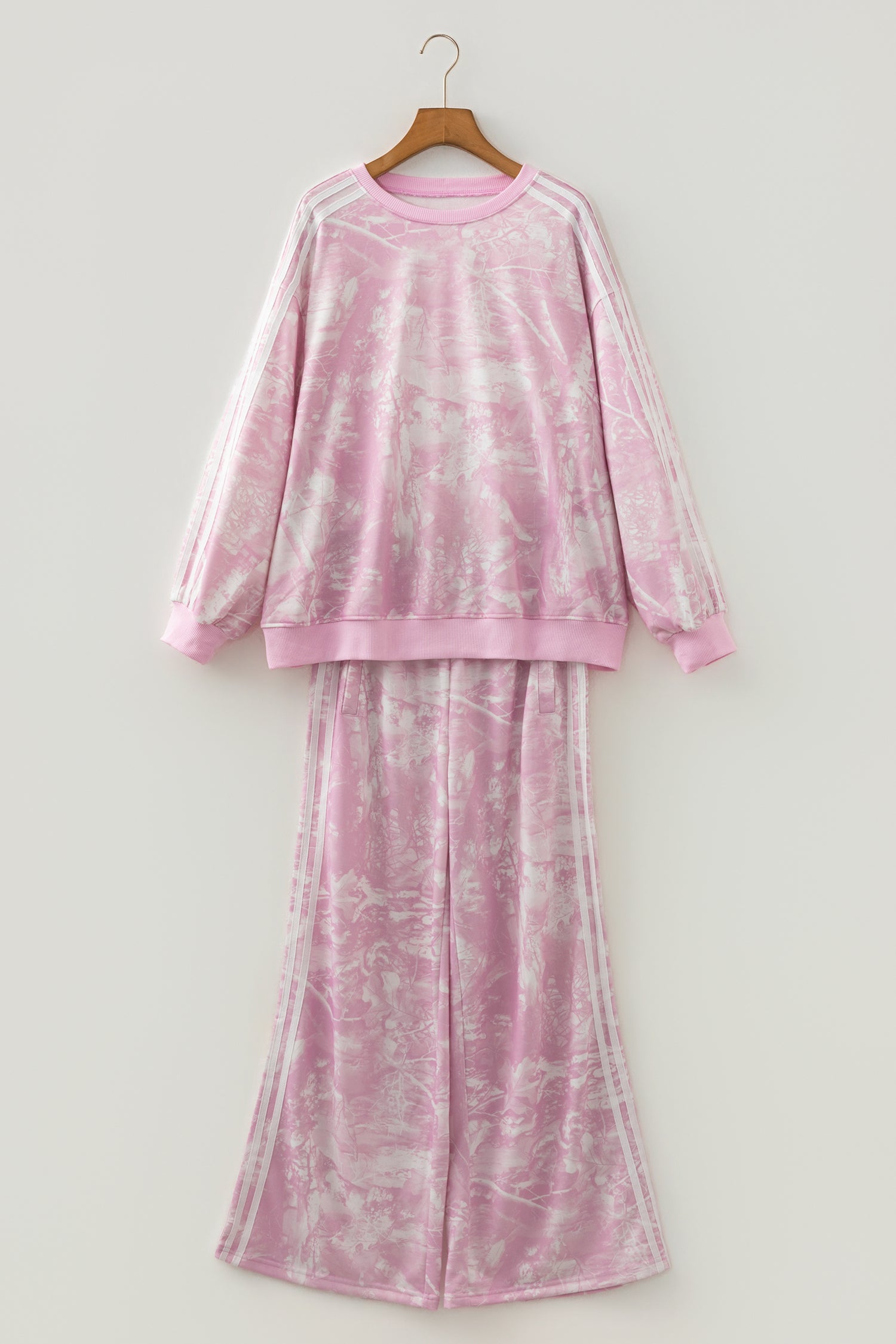 Pink abstract print sweatshirt and wide leg pants set on a hanger, front view