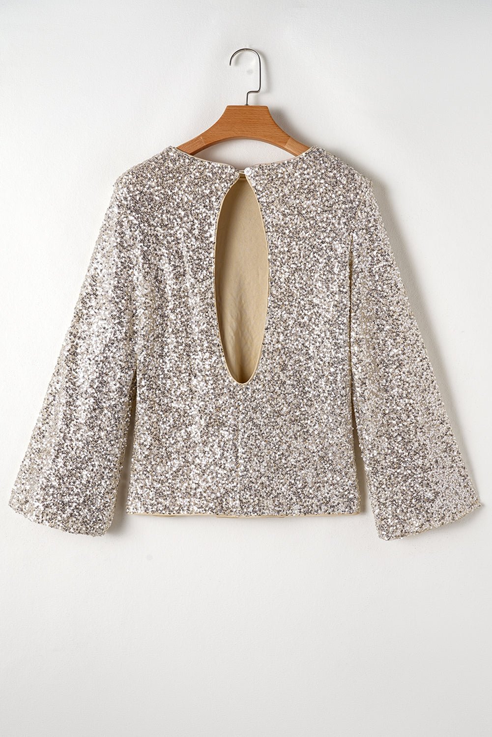 Floral blouse on a wooden hanger against a white background