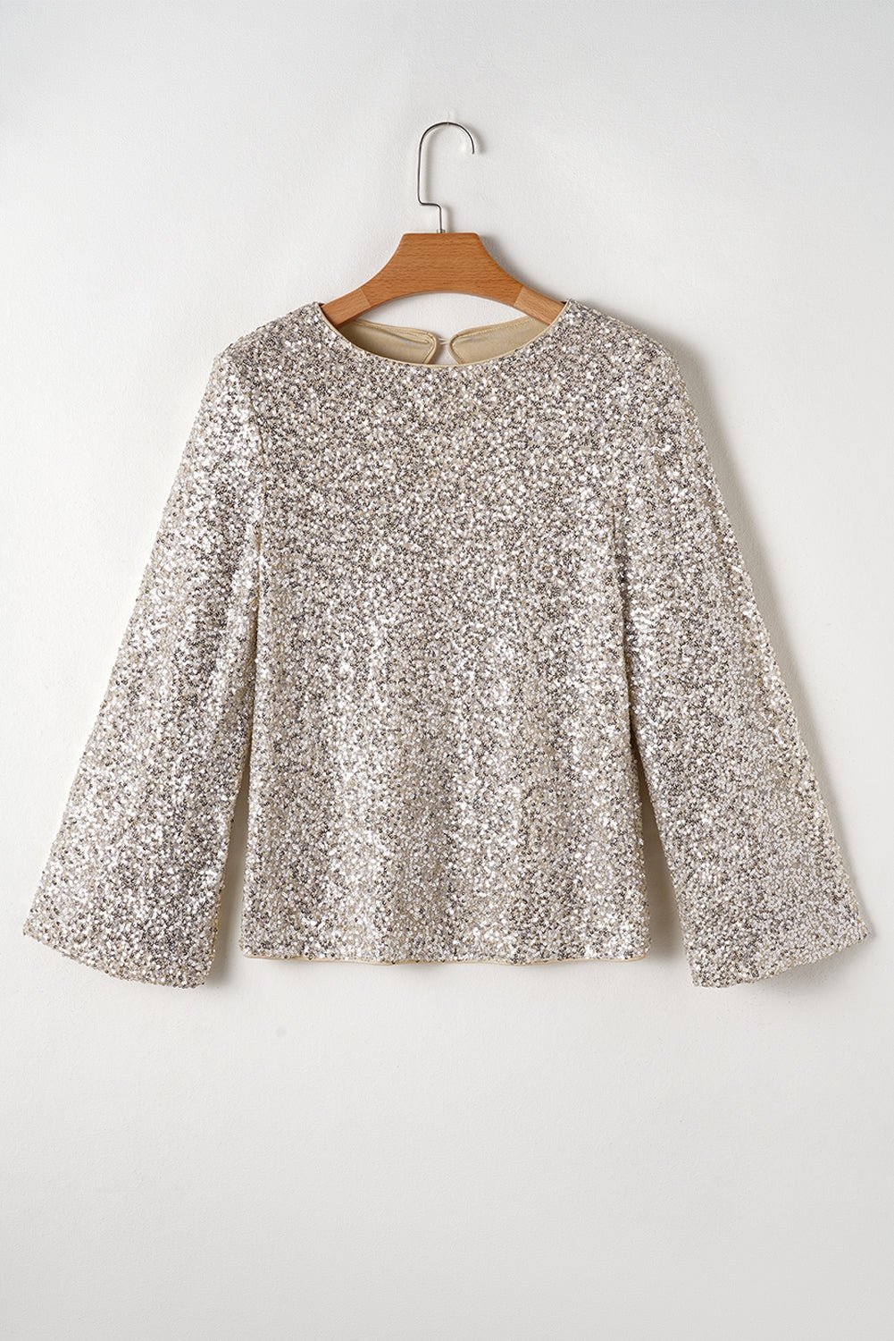 Floral blouse on a wooden hanger against a white background