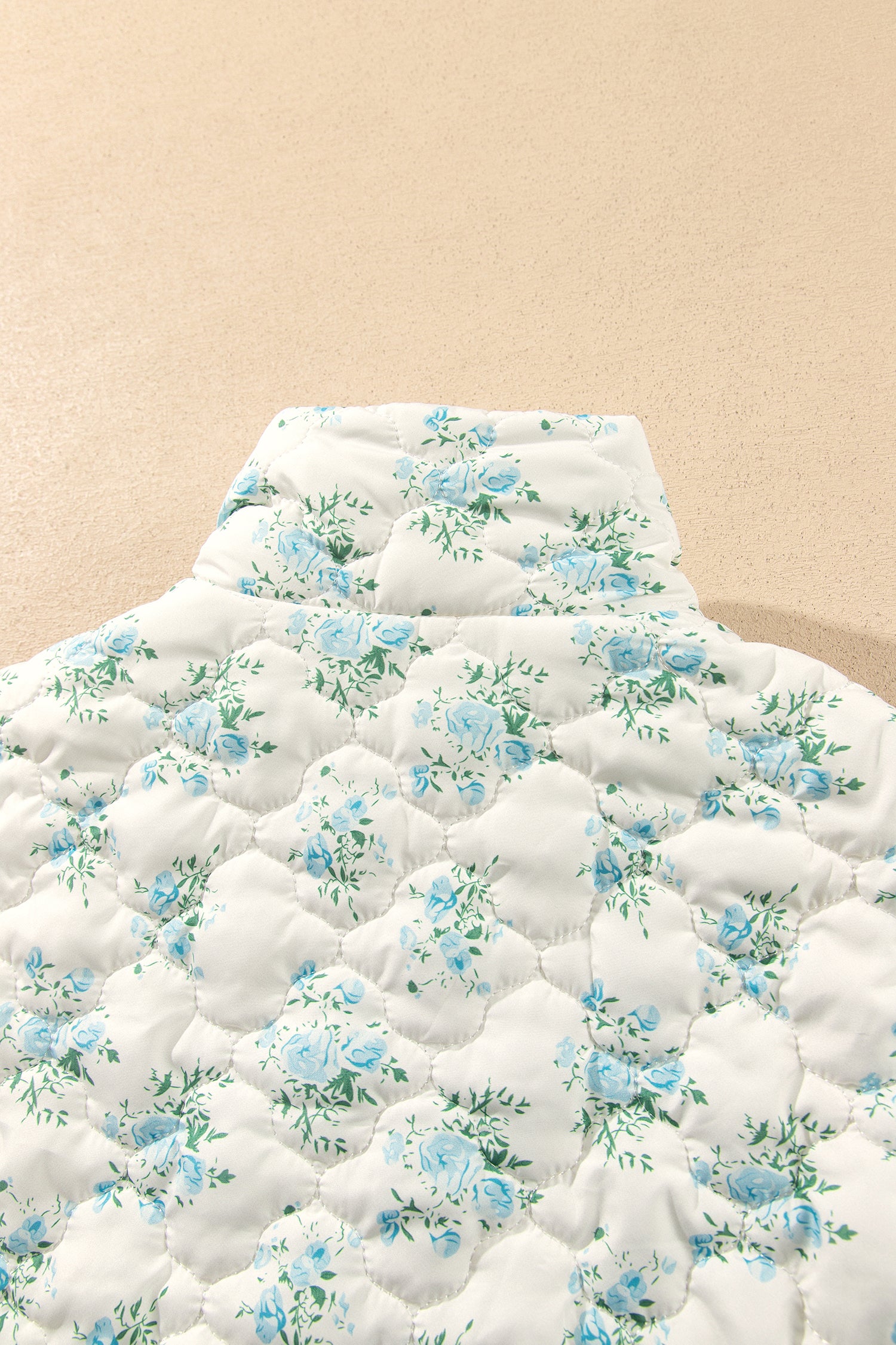 Close-up of back stand collar on sky blue floral quilted puffer jacket