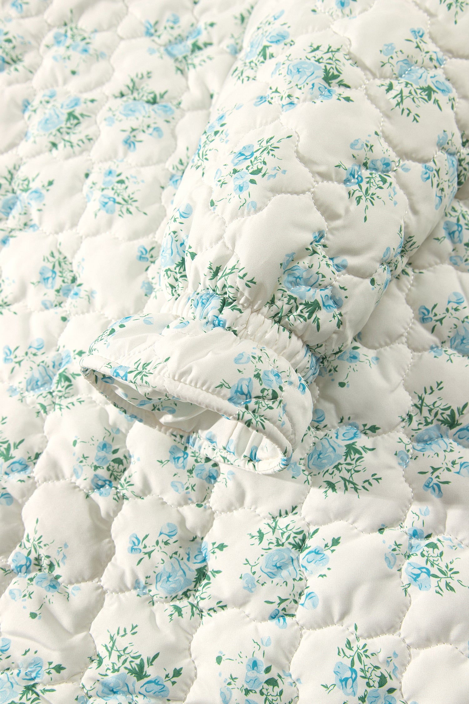 Close-up of sky blue and green floral print on quilted fabric