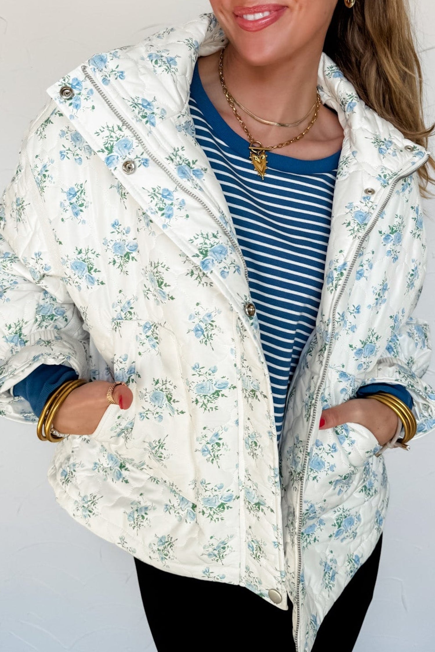Sky blue floral quilted puffer jacket worn open over a navy striped tee