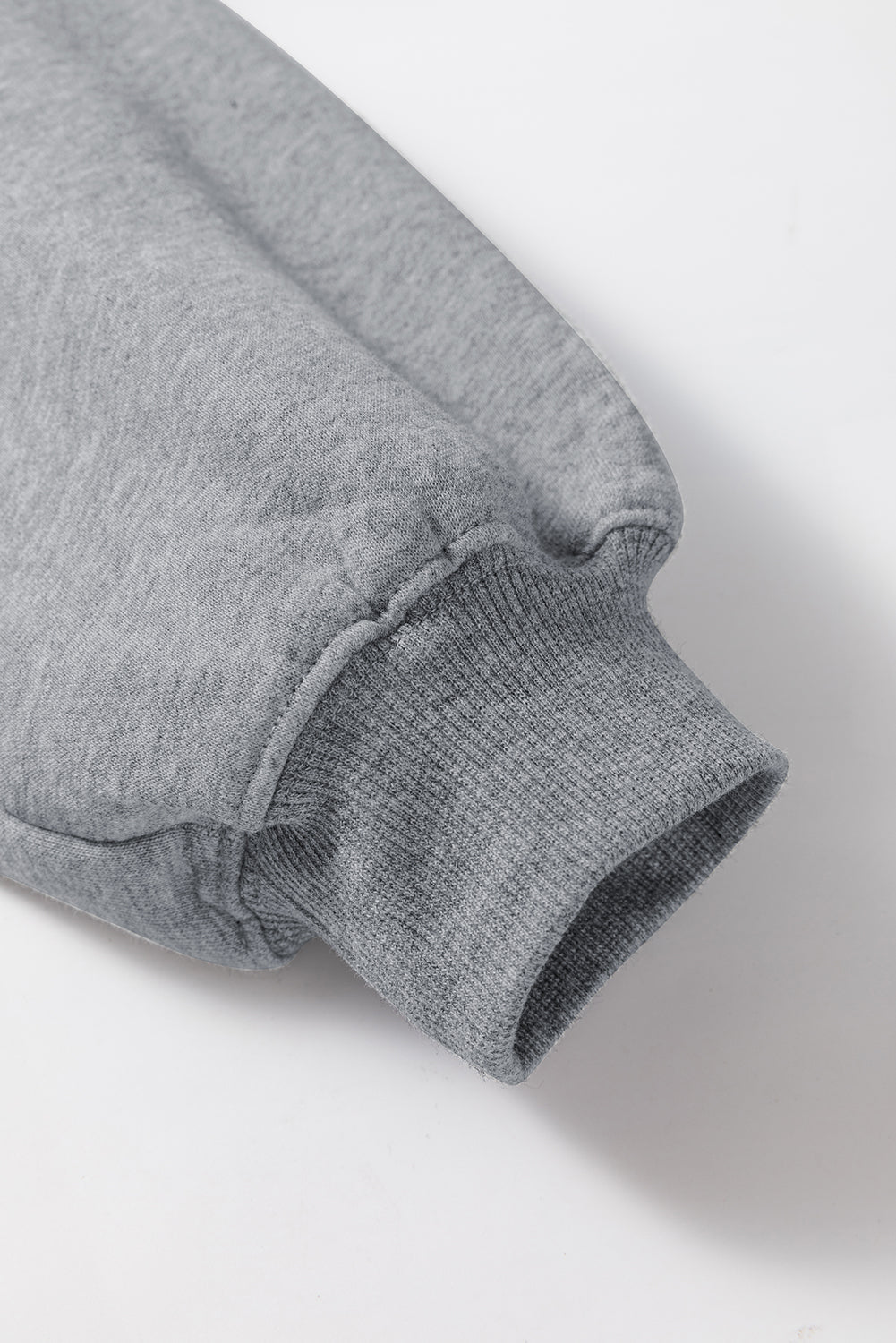 Close-up of a gray sweatshirt sleeve on a white background