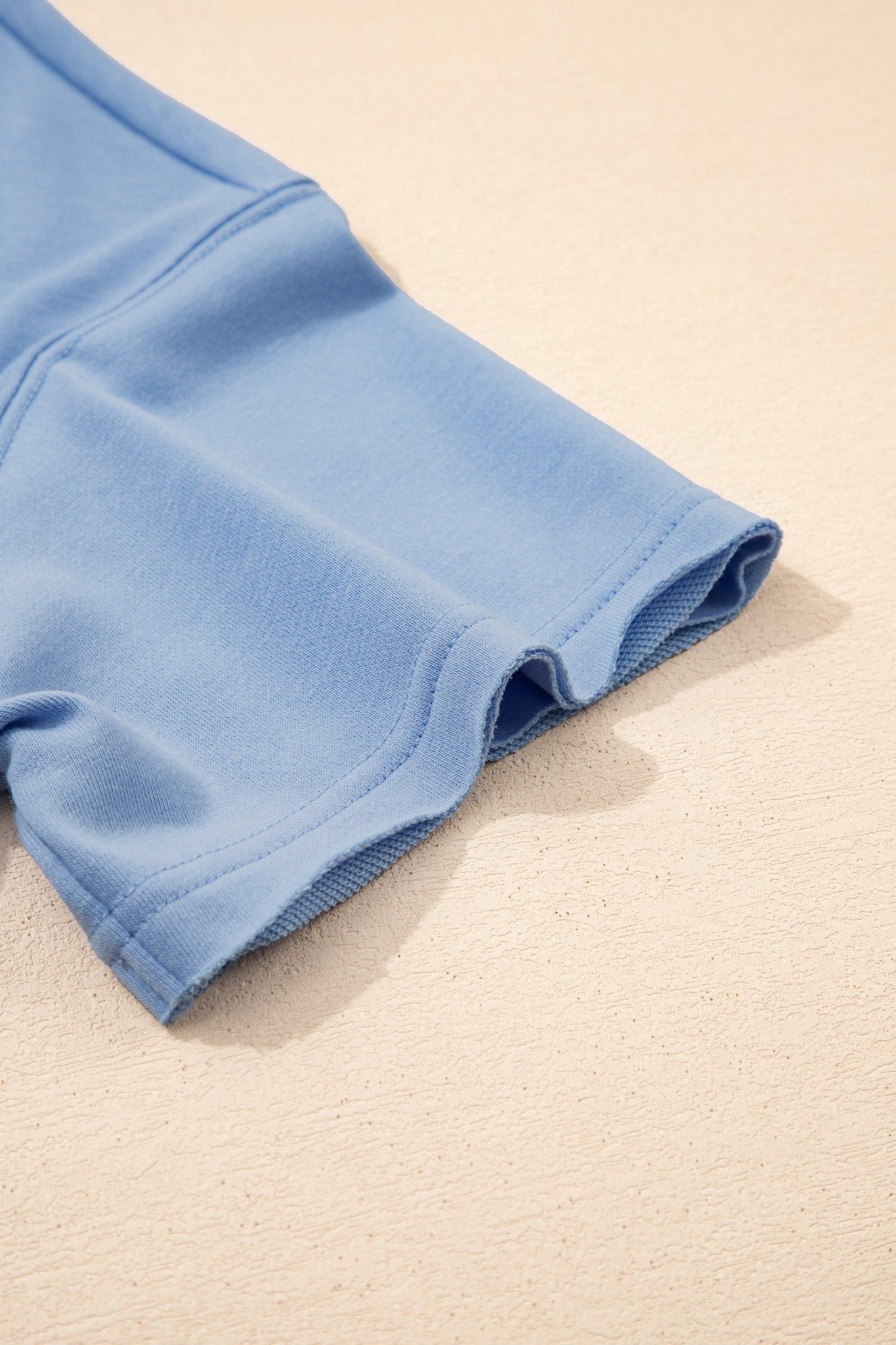 Close-up of blue shorts on a beige surface