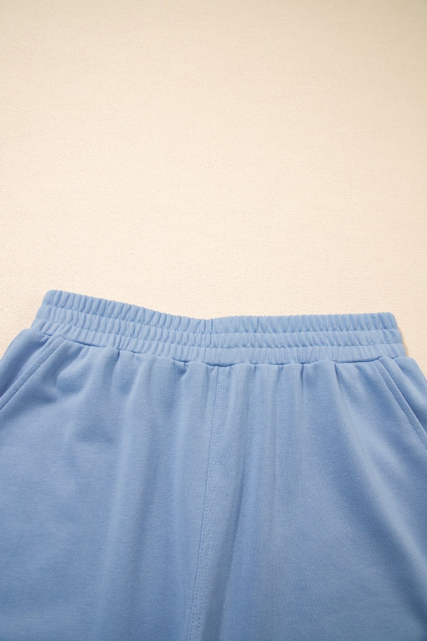 Close-up of blue pants on a beige background