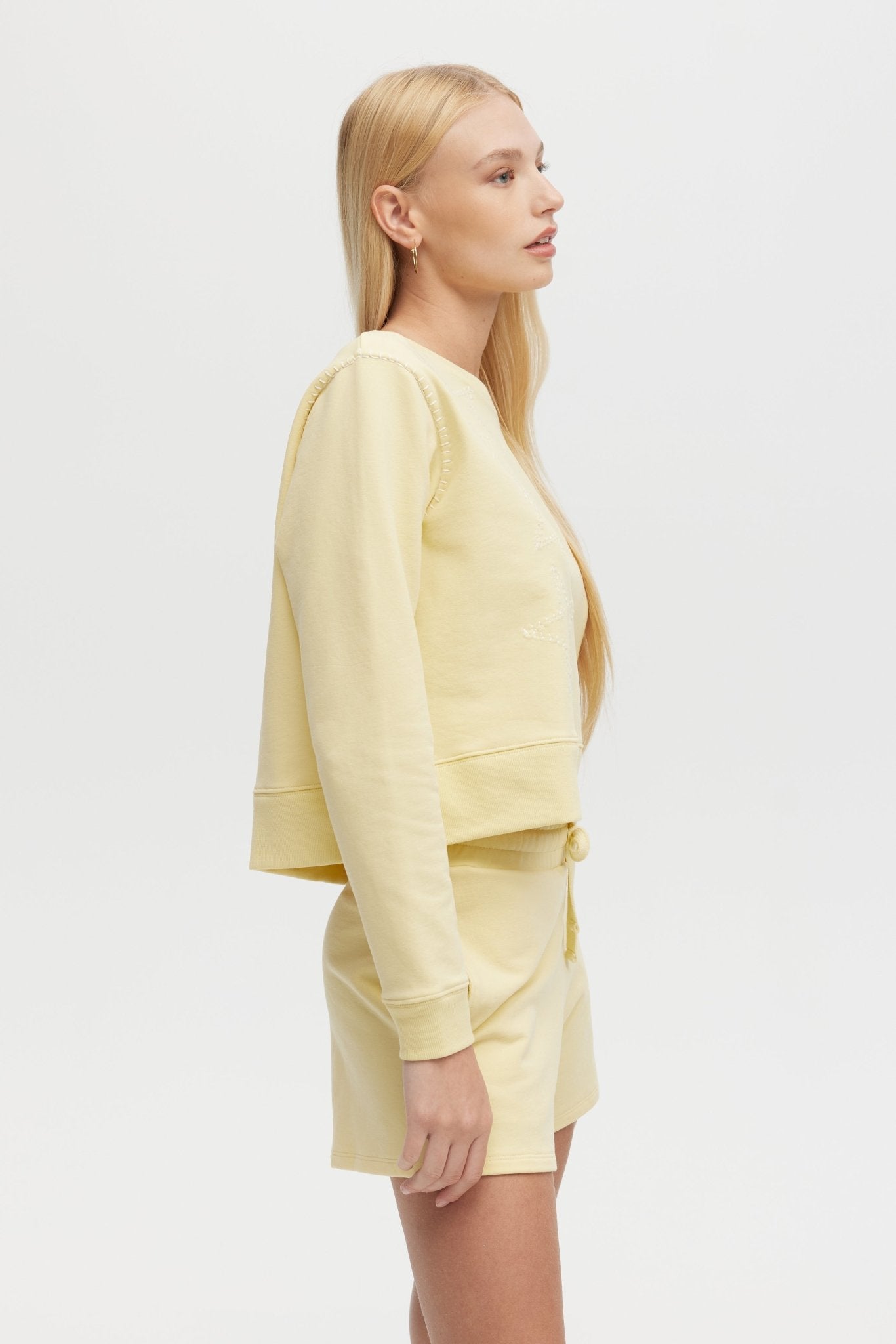 Woman wearing a light yellow outfit on a white background