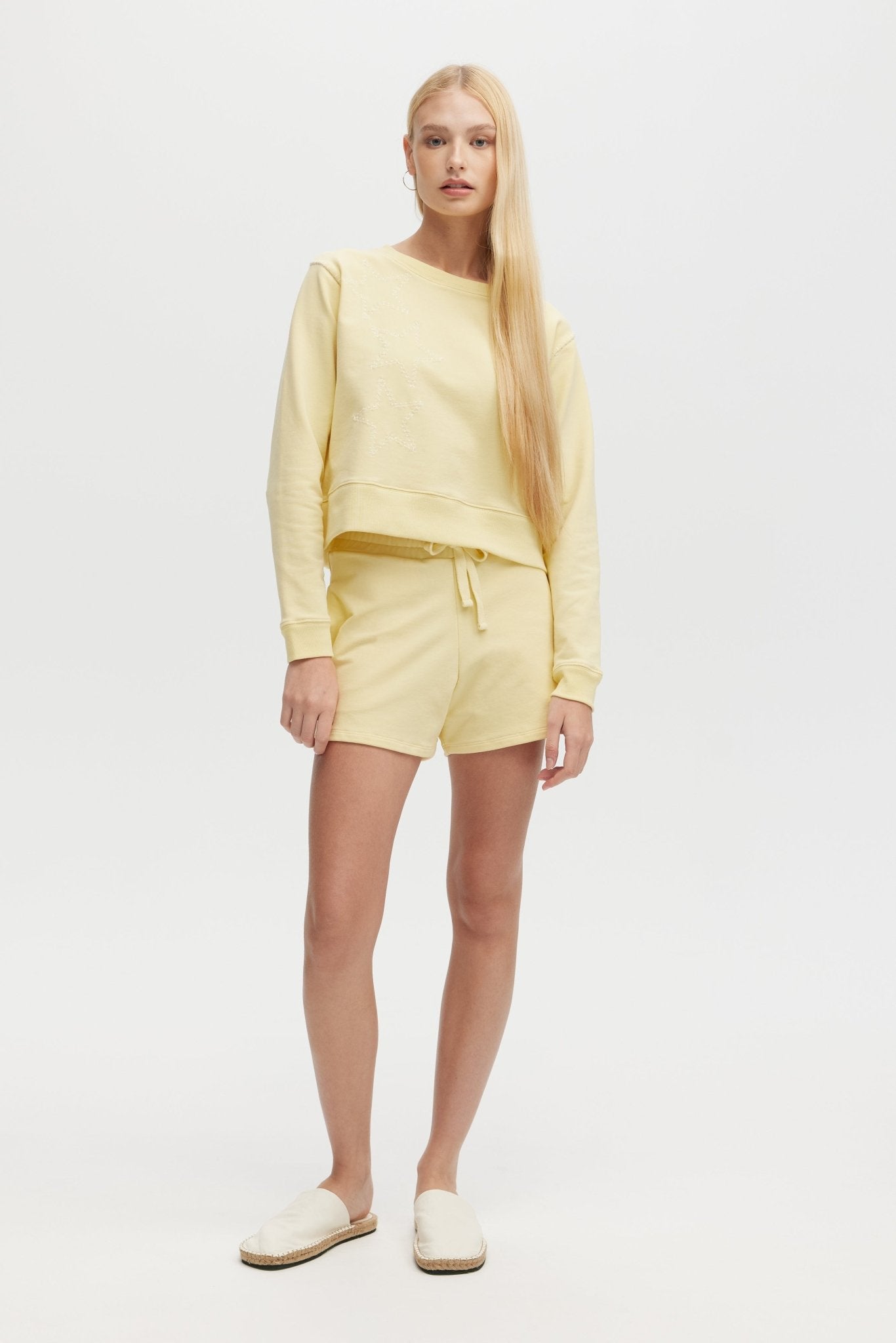 Woman wearing a yellow outfit on a white background