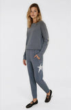 Woman wearing a gray sweatshirt and pants with a star design on a white background