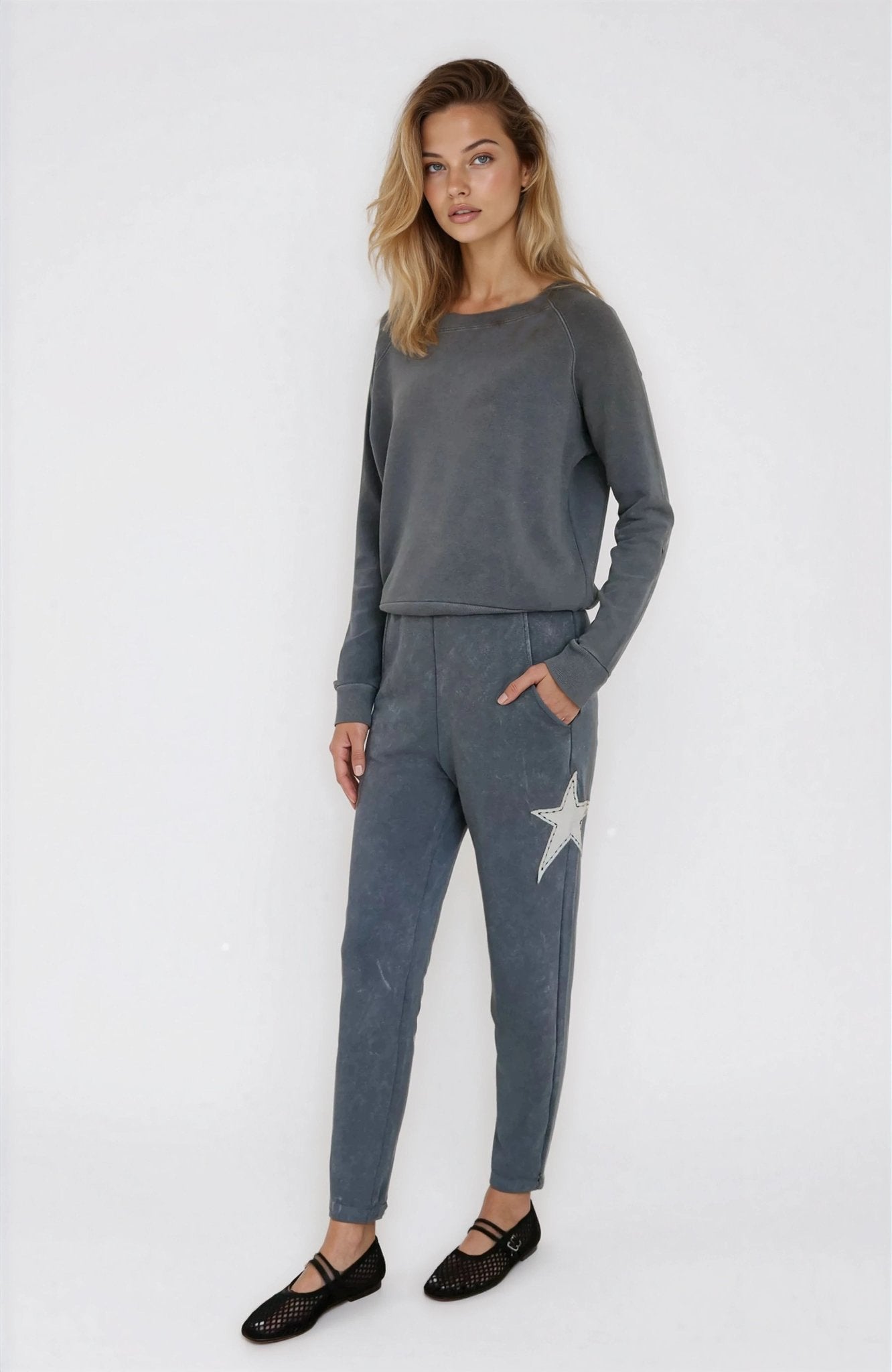 Woman wearing a gray outfit with a star design on a white background