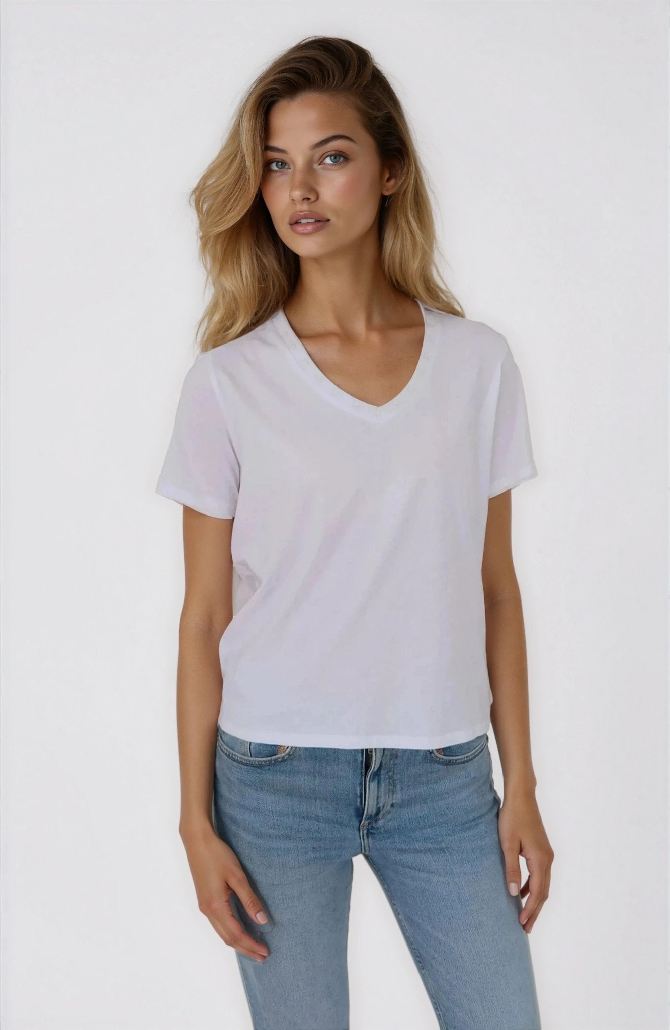 Woman wearing a plain white t-shirt and light blue jeans on a white background