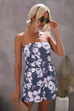Woman wearing a strapless floral dress against a gray background
