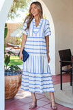 Woman wearing a blue and white striped dress standing outdoors.