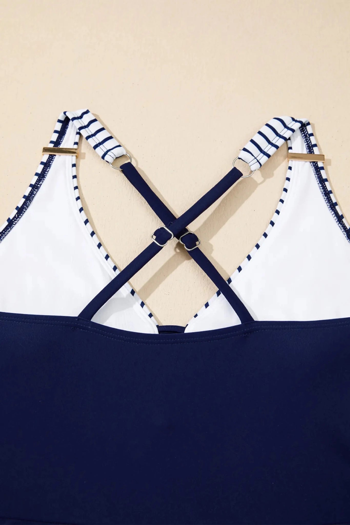 Navy and white striped top with criss-cross straps on a beige background