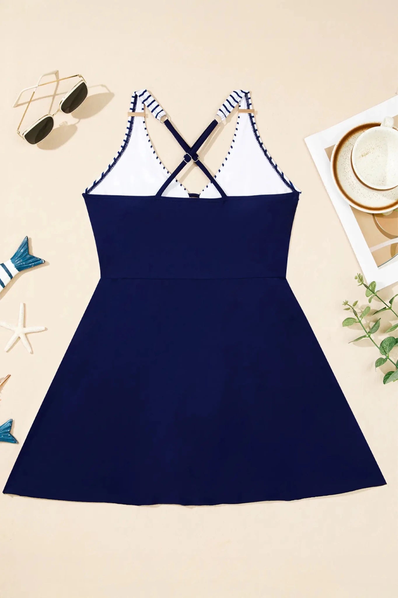 Navy blue dress with white lace details on a beige background