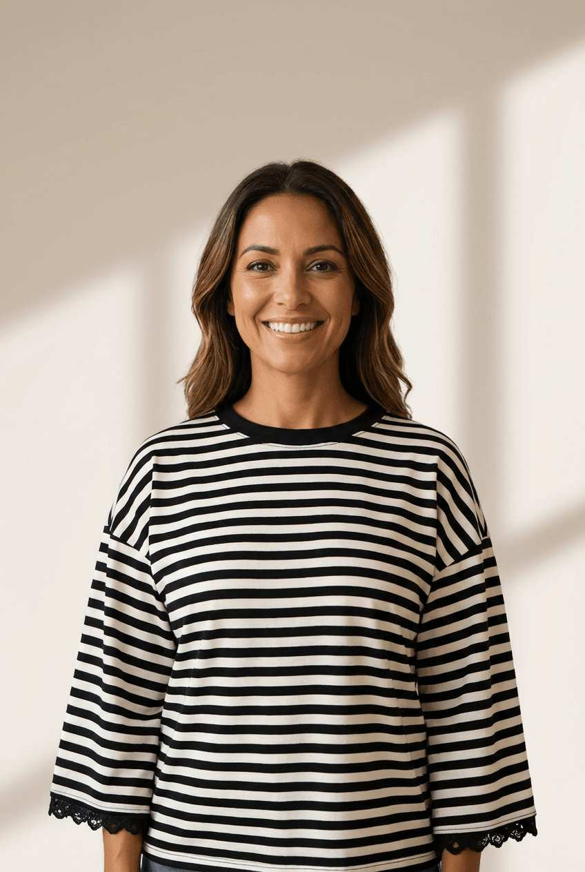 Woman wearing a black and white striped shirt against a neutral background