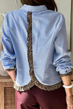 Person wearing a blue and white striped shirt with leopard print trim.
